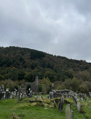 A cemetary and ruins flanked by mountains
