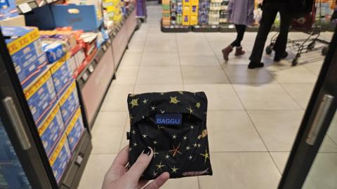 A reusable Baggu grocery bag, folded up.