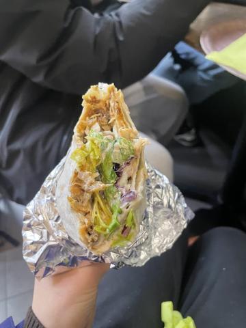 Holding a half-eat Döner wrapped in foil