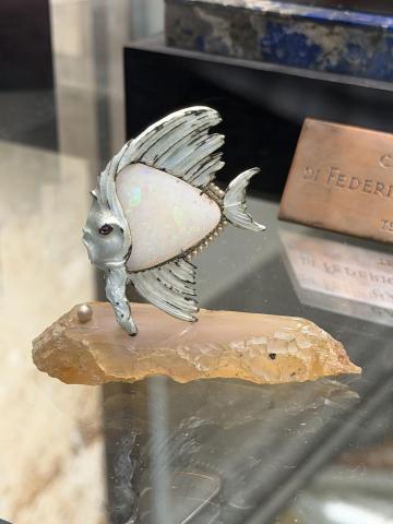 A sculpture of a fish triangle in shape made from opal.