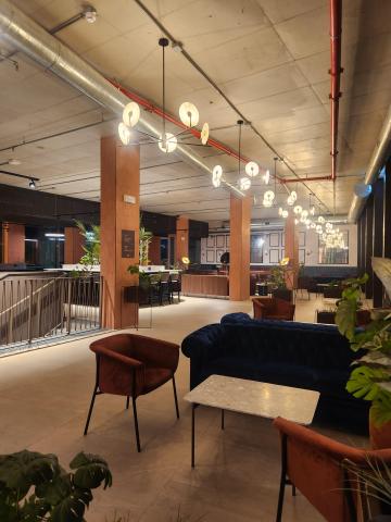 A common lounge area with tables, chairs, and study spaces inside Collegiate Milan Bovisa.