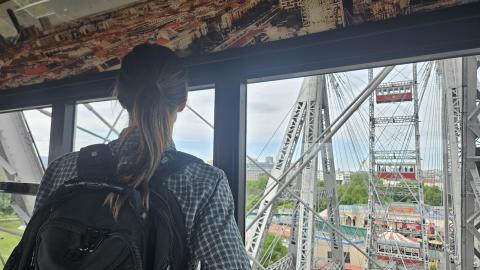 A shot from inside the Vienna Giant Ferris Wheel, showing the inside of the wheel, Prater, and the city below.