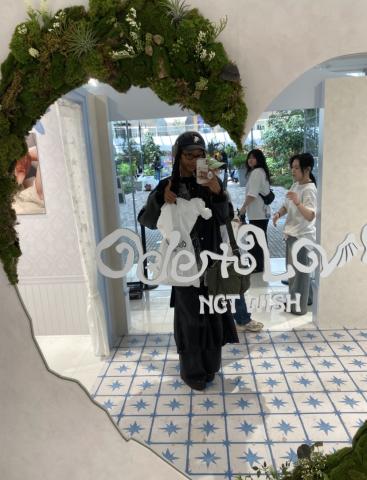 A mirror selfie of me holding a white shopping bag that says "NCT Wish" while doing a thumbs up. The mirror says "Ode to Love, NCT WISH".