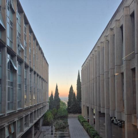 A sunrise shown between two concrete buildings