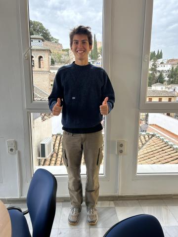 Male student wearing a blue wool sweater with khaki cargo pants