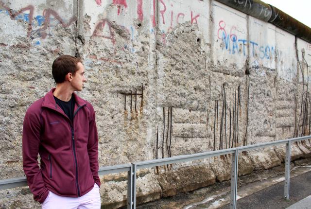 a student looks at the Berlin Wall