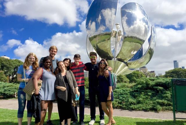 a group of students pose with the Floralis Generica sculpture