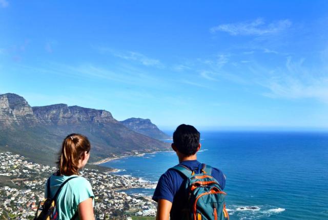 two students look over Cape Town's city and coastline from the mountaintops