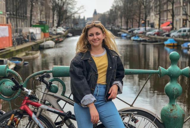 student posing in front of an Amsterdam canal