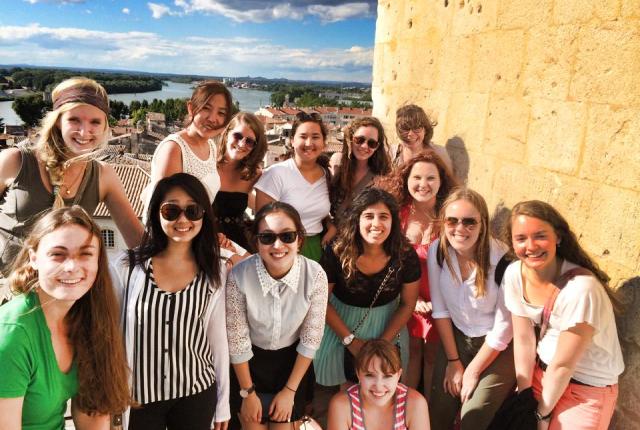 a group of students pose in front of an Arles cityscape