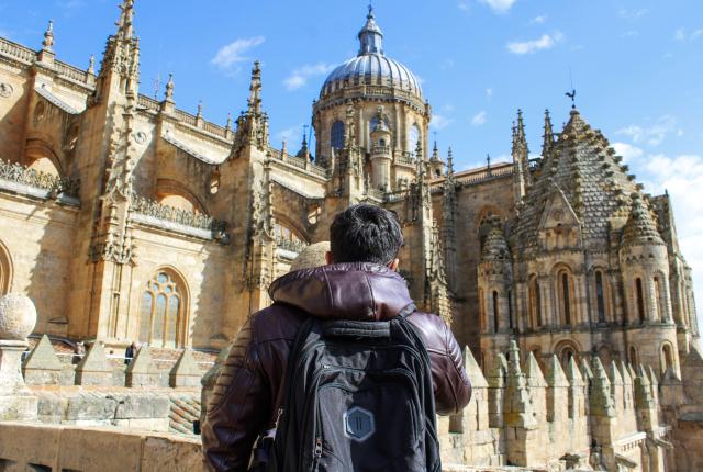 a student looking up at the beautiful New Cathedral of Salamanca