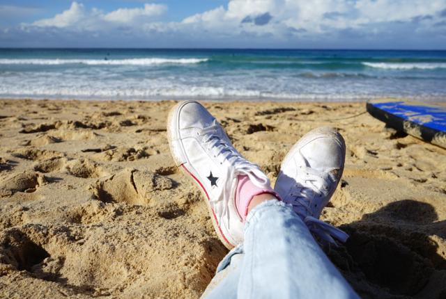 an artistic shot of a student's shoes on a beach in Sydney