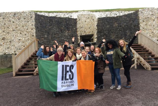a group of students pose with an IES Abroad Dublin flag