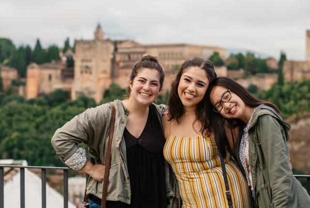 students pose for a photo in front of Alhambra Palace in Granda