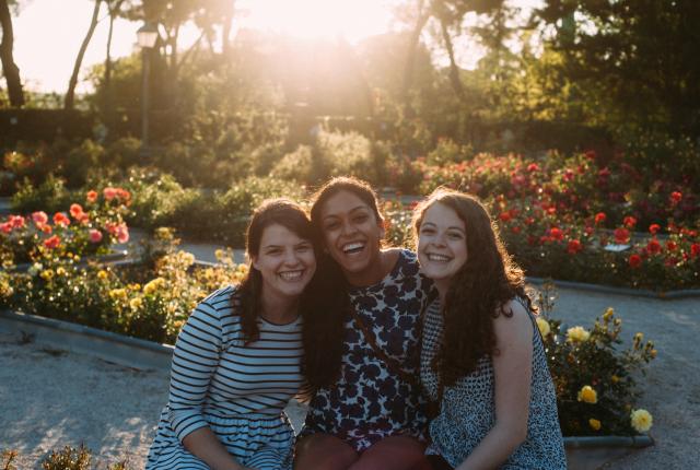students smile for a photo in a flower-filled Madrid park