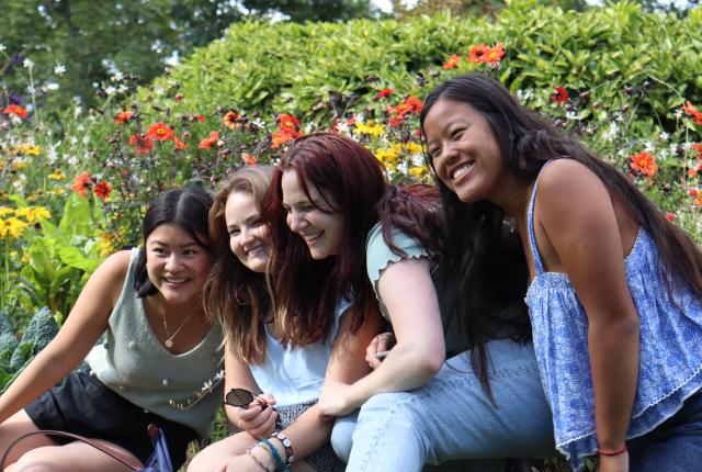 a group of students pose for a fun photo in a garden with flowers in Nantes