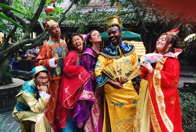 a group of students pose for a fun photo wearing traditional Chinese garments