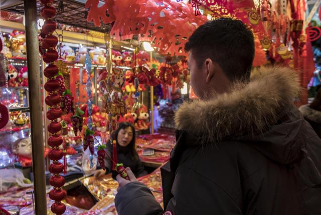a student looks at souvenirs at a Chinese street market