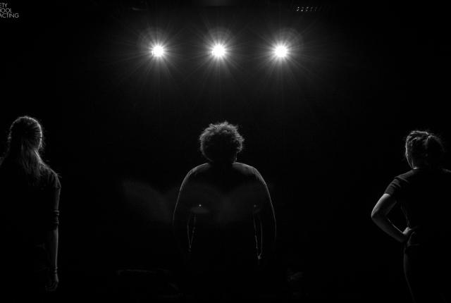 a student standing on stage facing the spotlights