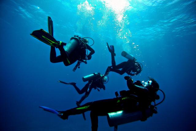 four students scuba diving in Galápagos