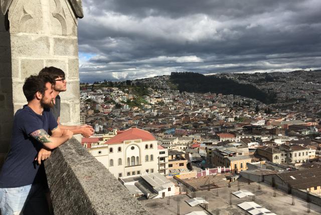 students looking out over Quito city from the top of a cathedral
