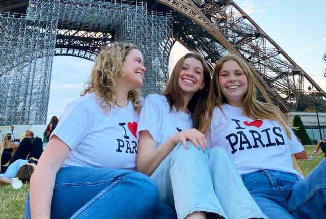 three female students having fun at the Eiffel Tower