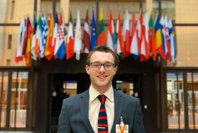 Male student standing in front of the EU council building