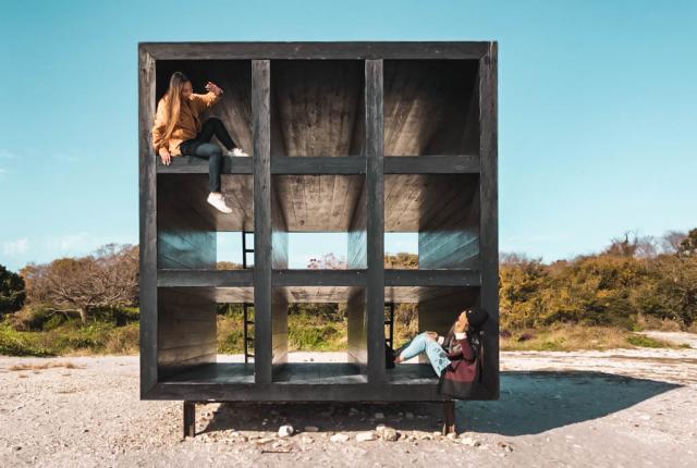 Two students sit in an art installation in Sakushima Island