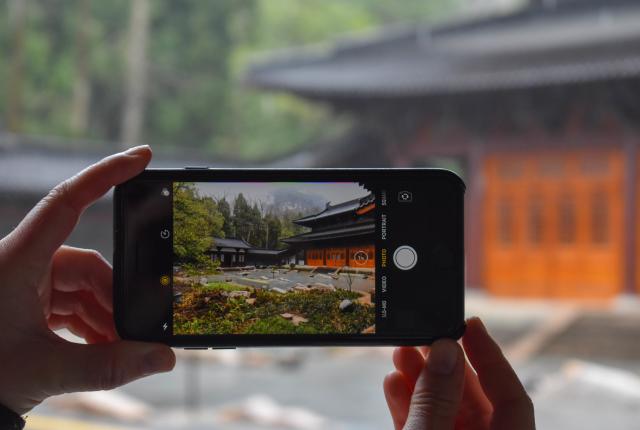 a student taking a photo of a temple in China on an iPhone