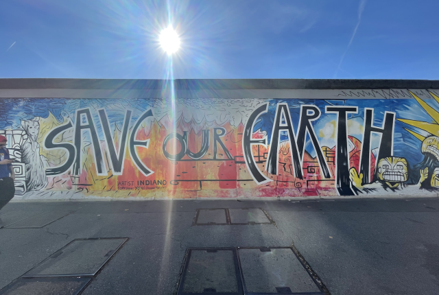 On the Berlin Wall is spray painted "Save Our Earth."