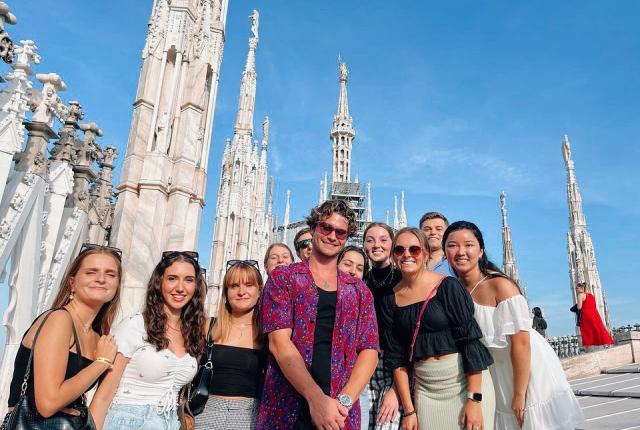 A group of students smile outside Il Duomo in Milan, Italy.