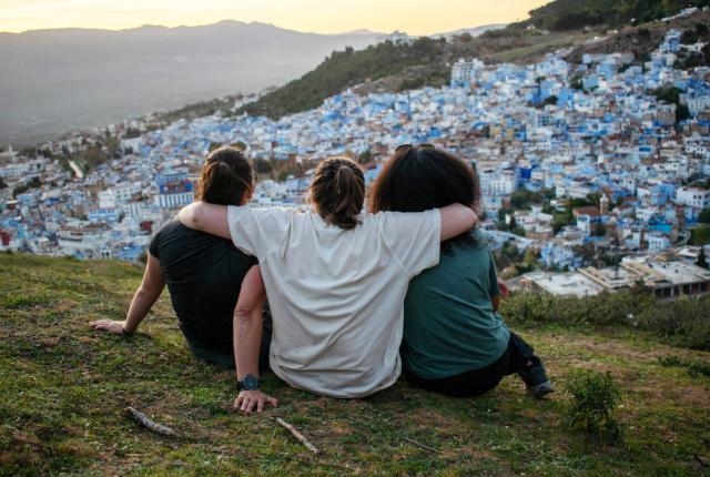 Three students overlook Chefchaouen, a city in Morocco dotted with blue buildings.