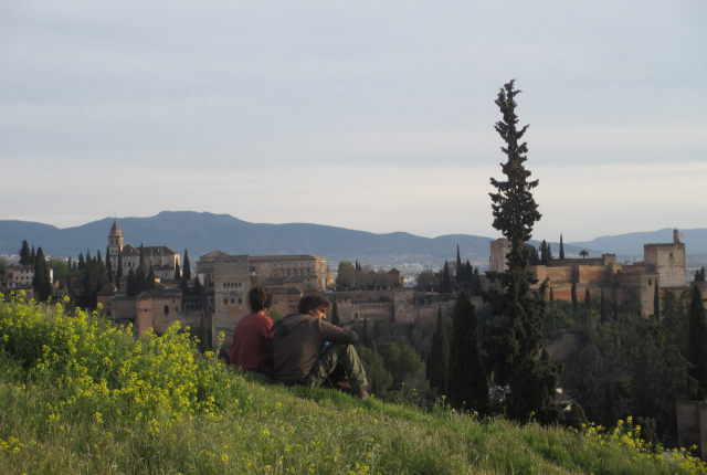 Students sit on a hill overlooking the city in Granada, Spain.