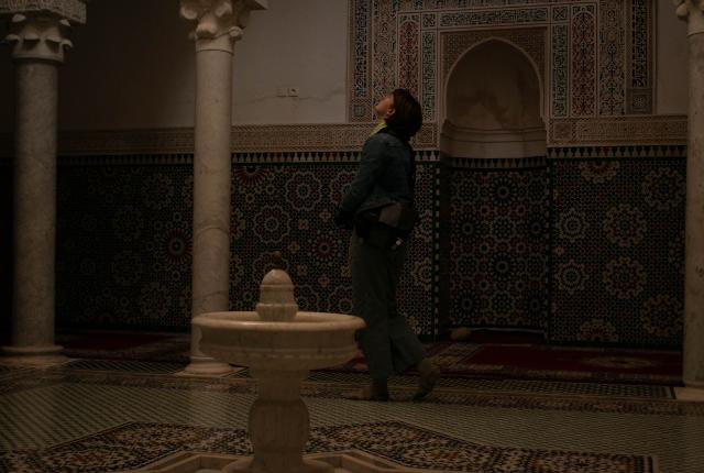 A student looks at the ceiling of the Mausoleum of Moulay Ismail.