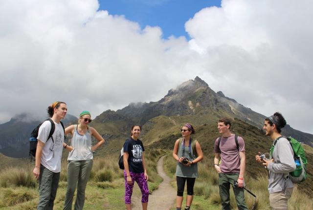 a group of students standing in a group to take a break during a hike in Quito's mountains