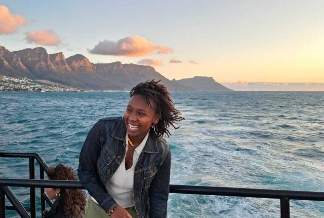 Student smiling in front of Cape Town ocean view