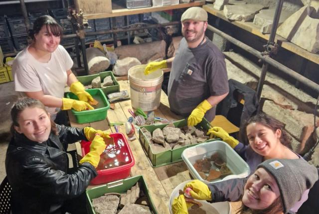 Students smiling with artifacts in the Colosseum during their internship