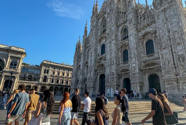 Group of students walking past the Duomo in Milan on a sunny morning