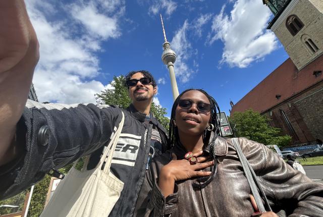 Myles and a friend take a low-angle selfie with the blue sky in berlin.