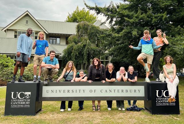 a group of students pose for a photo with the UC Canterbury sign