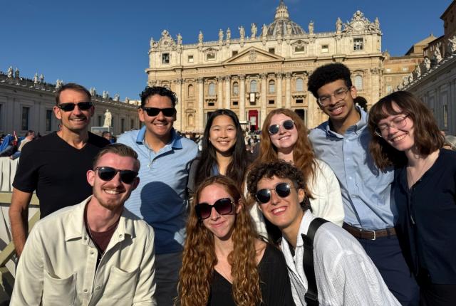 A group of students smile in front of the Vatican