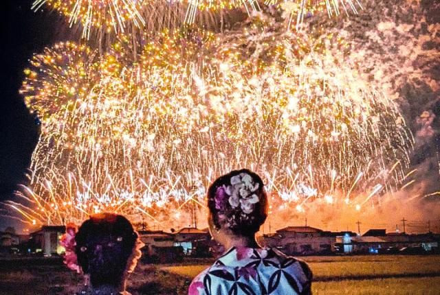 Tokyo Tonegawa Fireworks with two students standing in front of them