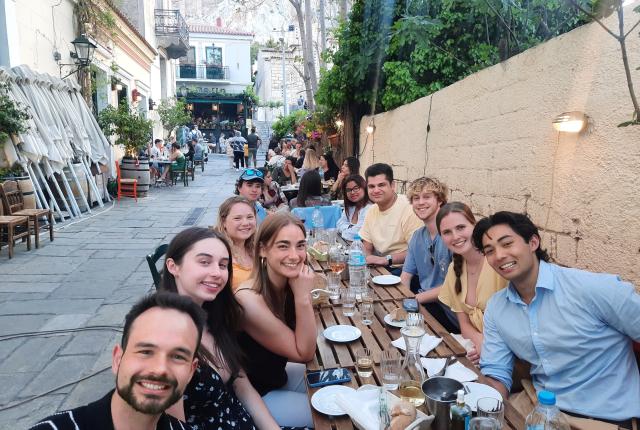 Students at a dining table outside in Athens