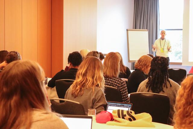 A group of people listening to a presentation