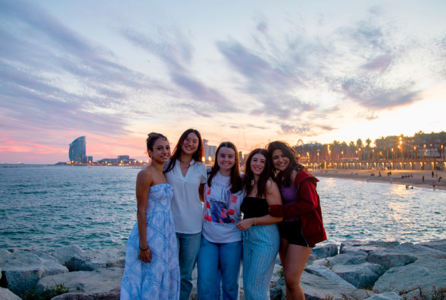 Friends soaking up the sunset on a trip to Barcelona, Spain