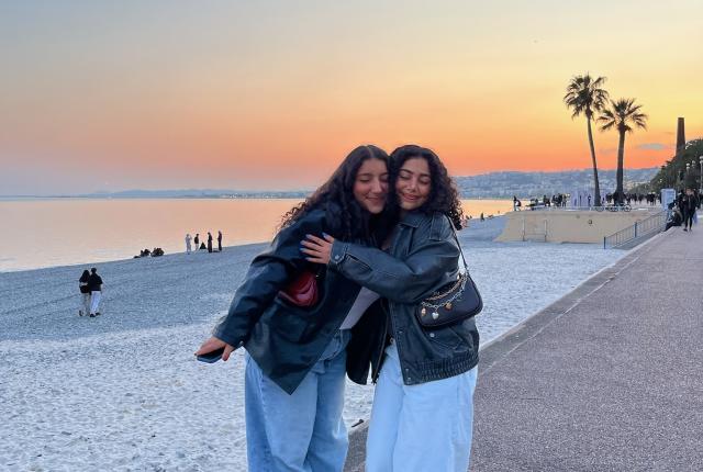 two students hugging on Nice beach at sunset