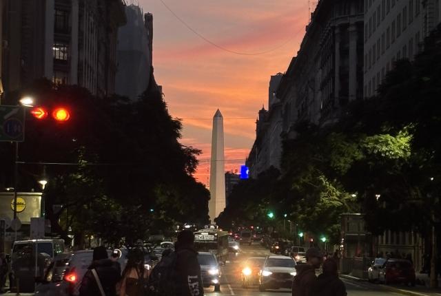 cars driving by during sunset downtown Buenos Aires, in front of the Obelisco monument