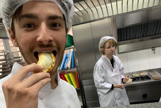 a student eating an empanada during a cooking class