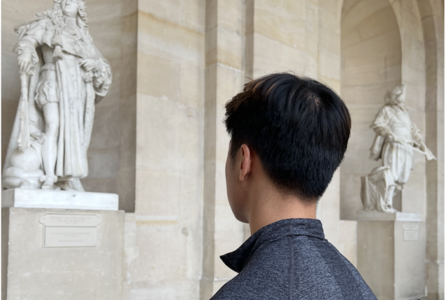 student looking at statue in Versailles
