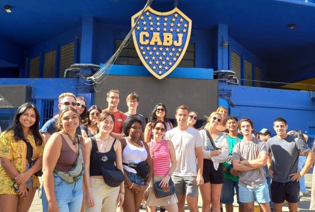 a group of students pose for a photo in front of the Buenos Aires futbol stadium